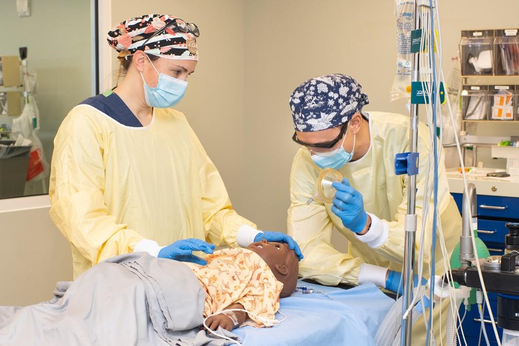 两名大学医学系学生在病人模拟器上练习